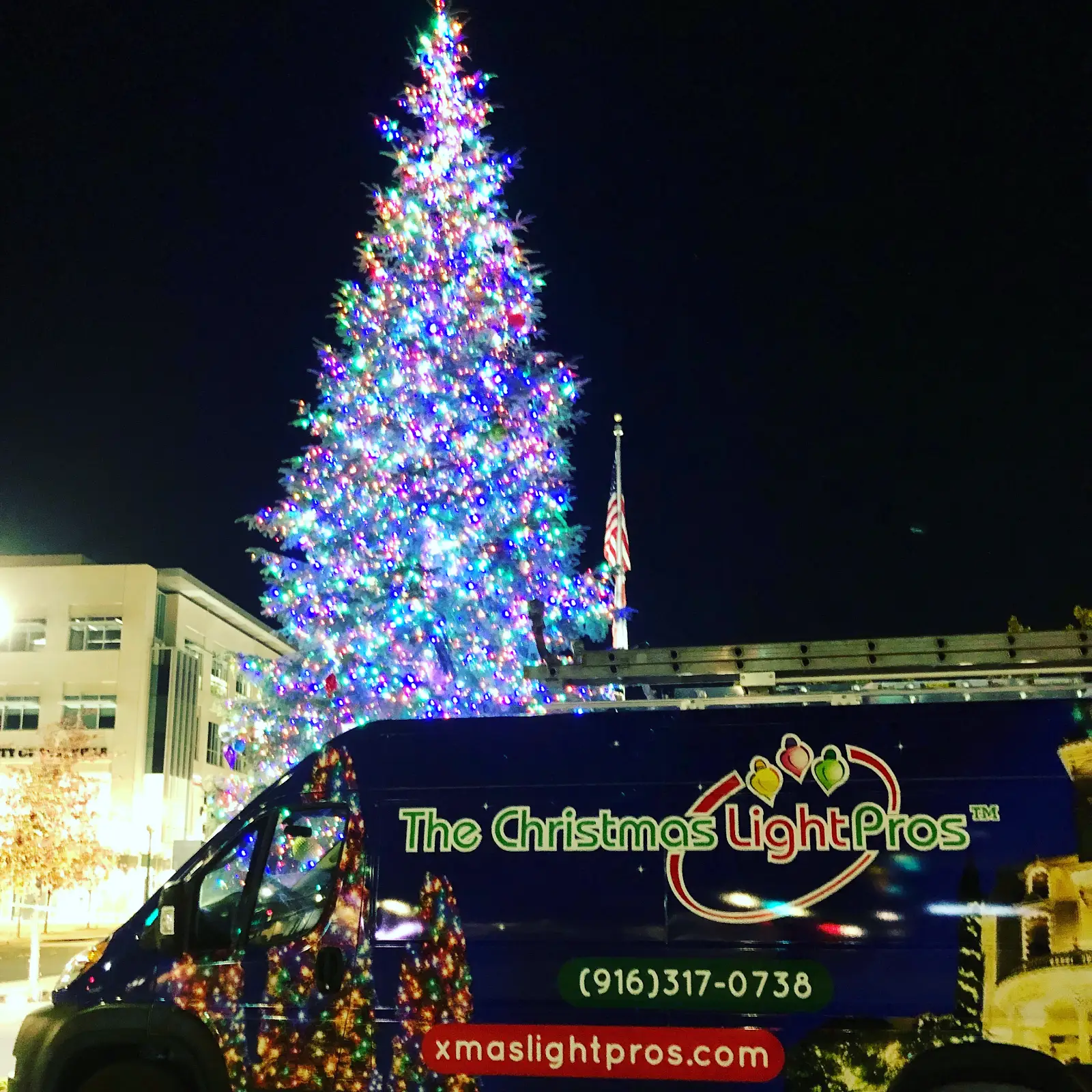 The Christmas Light Pros vehicle in front of Roseville's decorated Vernon Street Town Square Christmas tree
